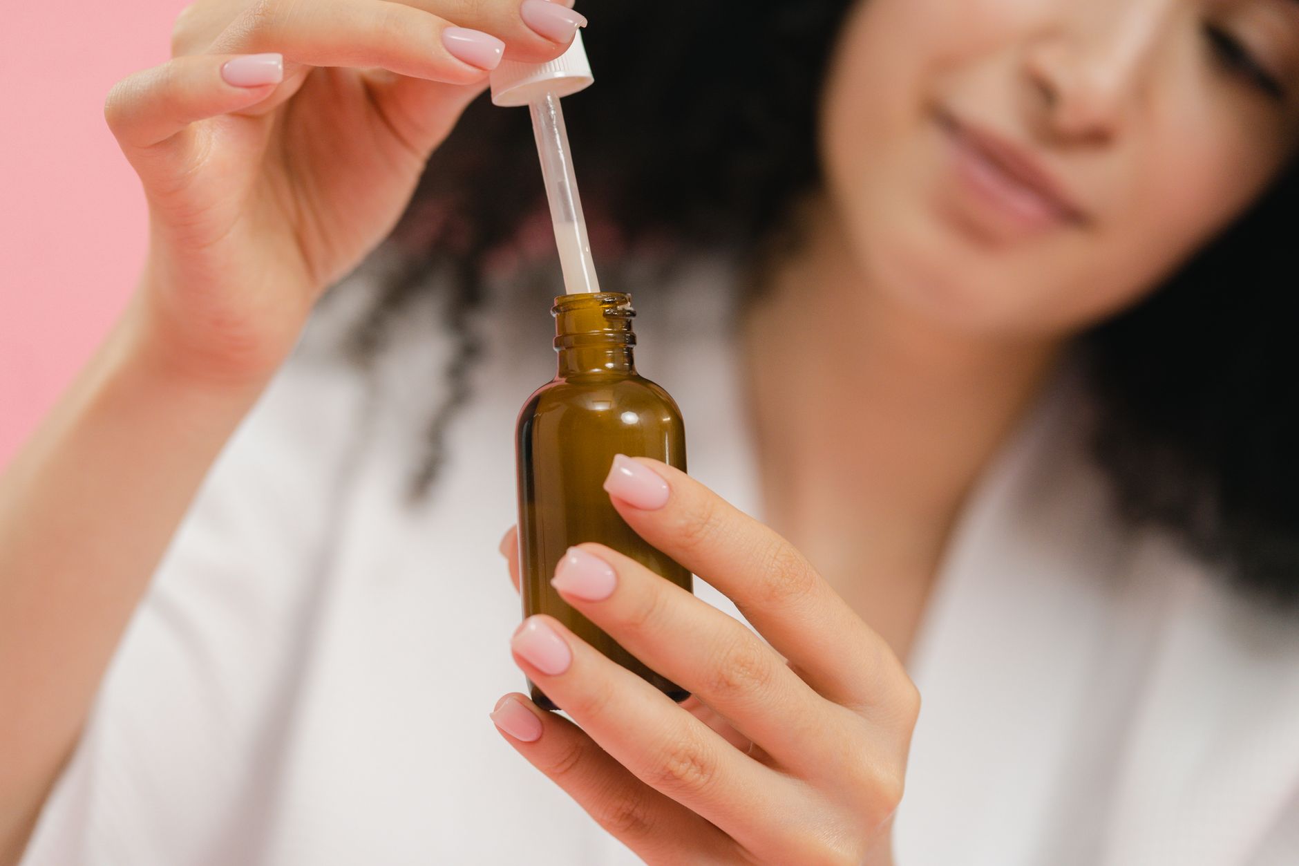 Applying a Korean facial serum with a dropper.