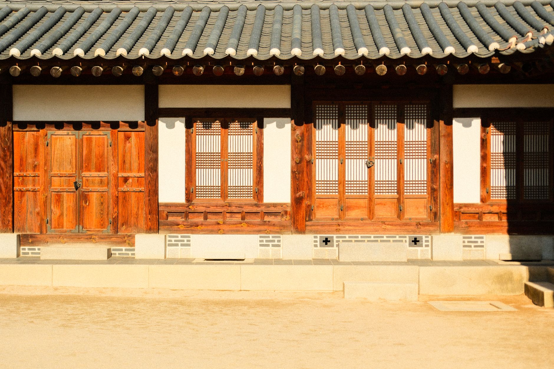 Elegant front view of a traditional Korean hanok house with wooden doors and tiled roof.