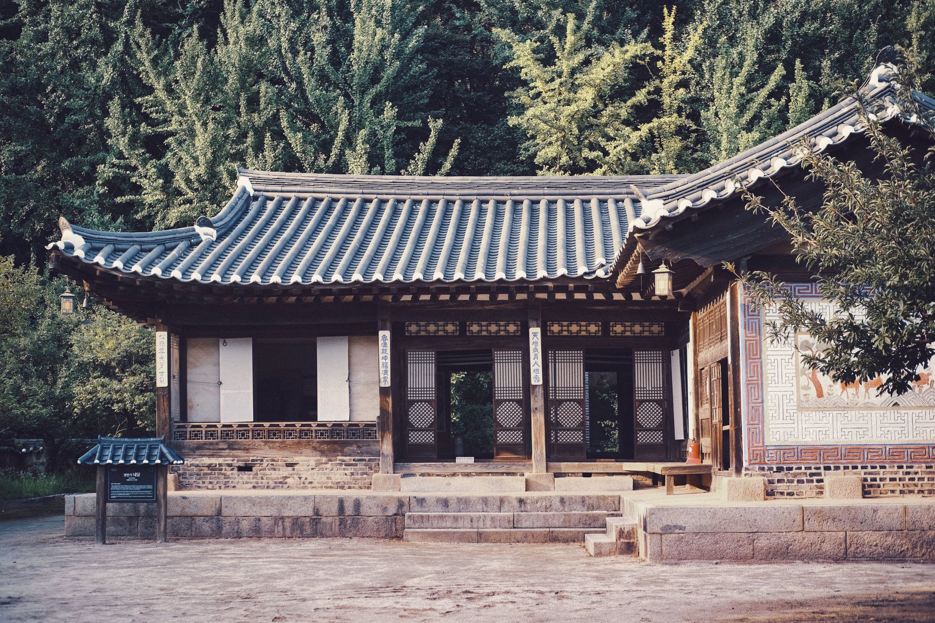 A serene Korean hanok set amidst lush greenery, showcasing traditional architecture.