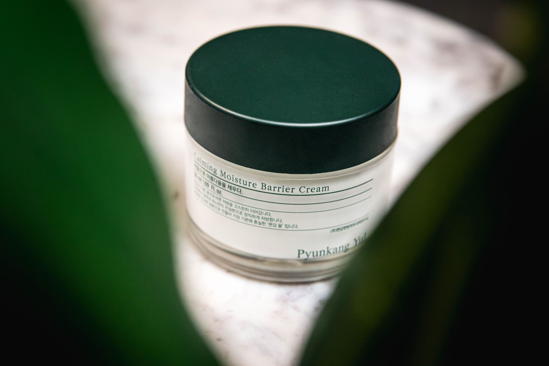 Close-up of Pyunkang Yul Calming Moisture Barrier Cream displayed on a marble surface.
