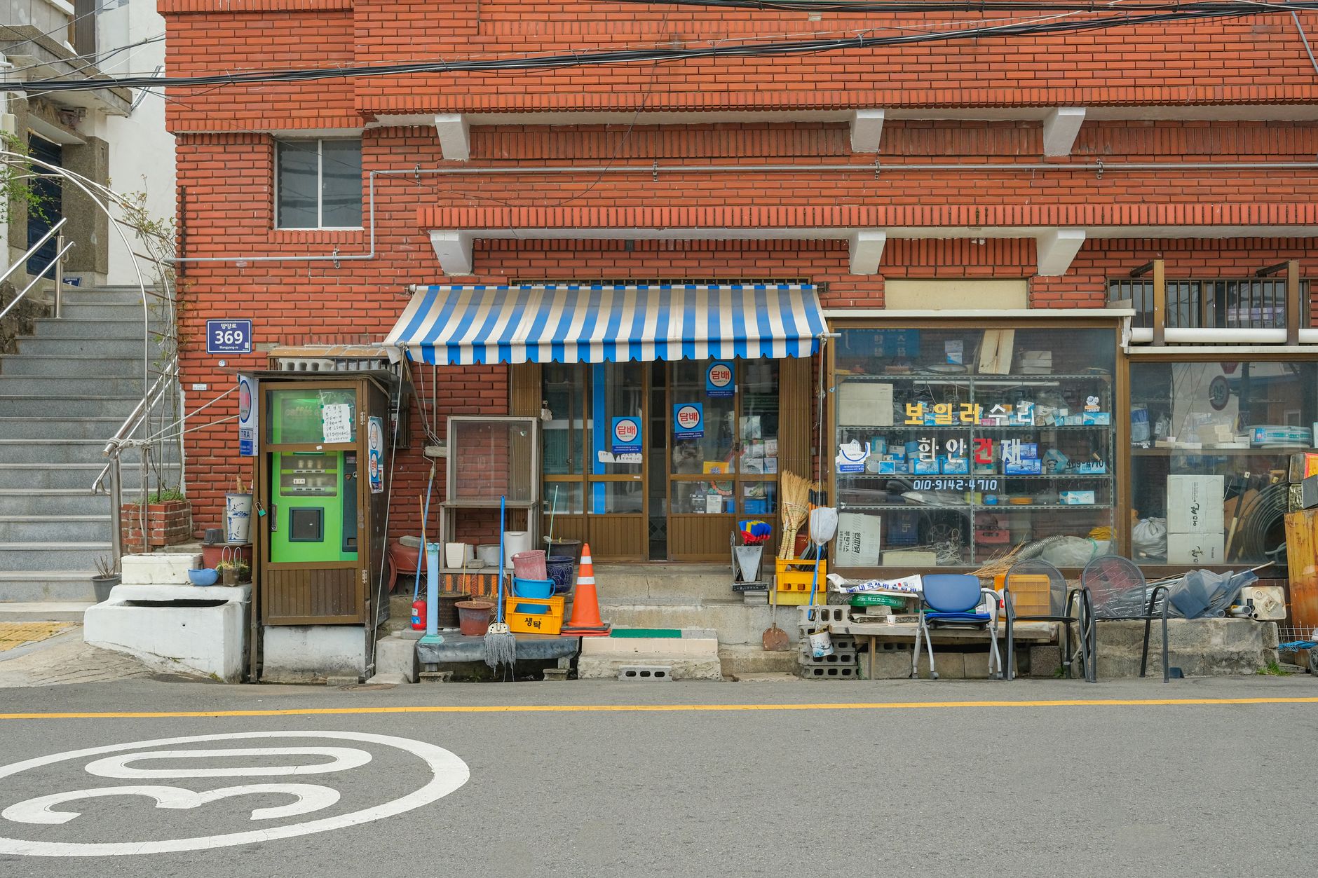 A quaint urban storefront with a retro feel, featuring a striped awning and eclectic store displays.