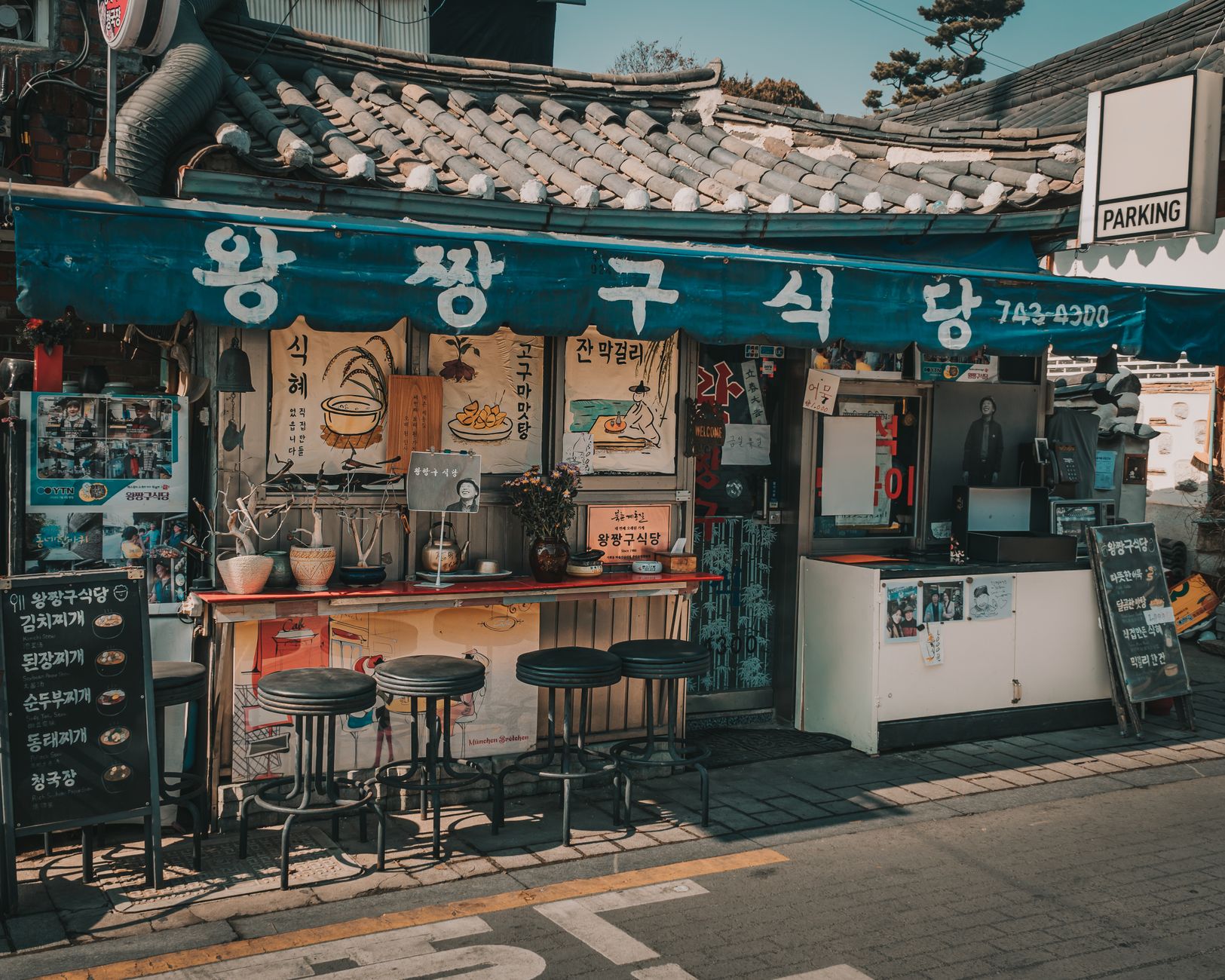 Traditional street food restaurant in Seoul with outdoor seating, showcasing Korean architecture and culinary culture.