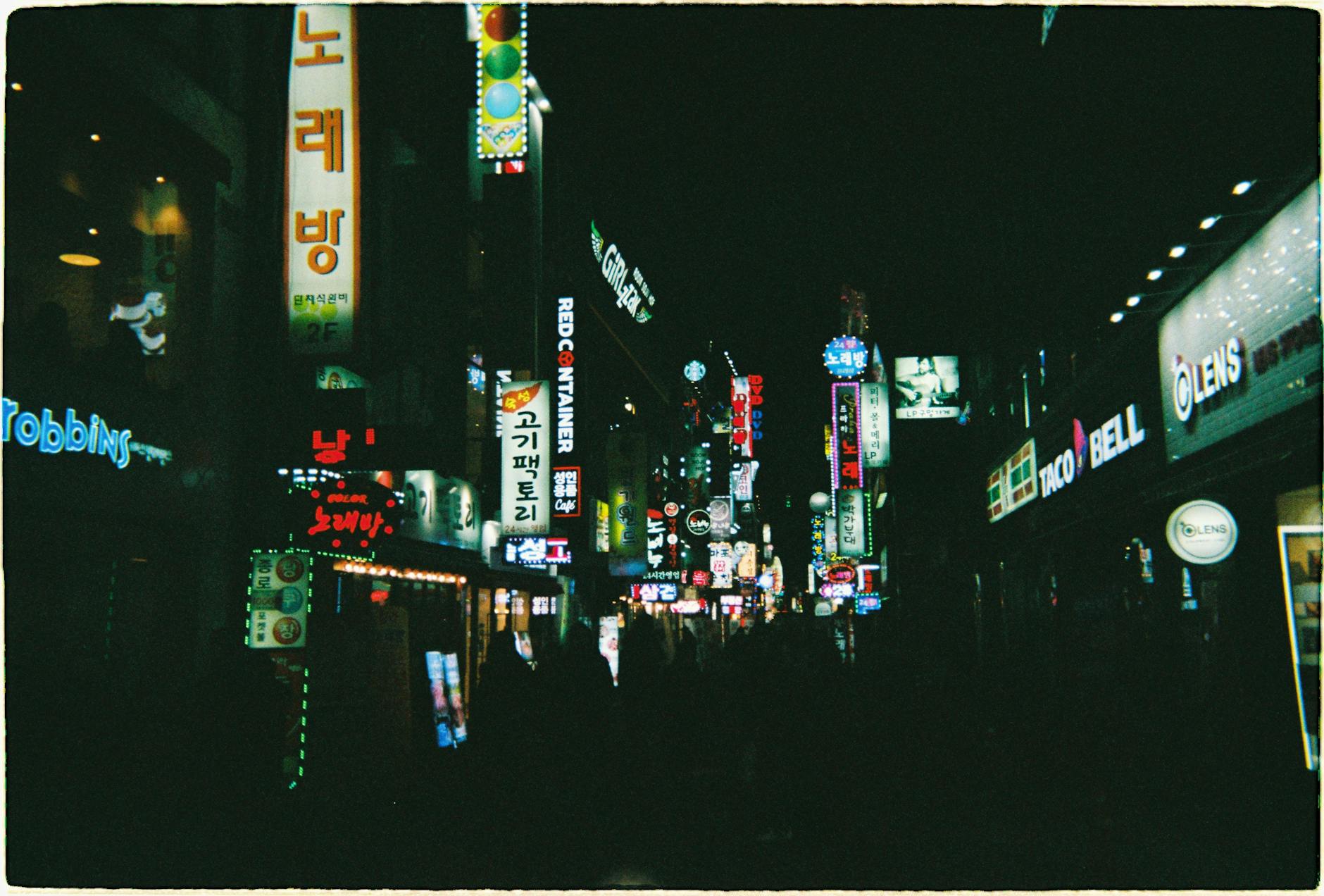 Dynamic cityscape of Seoul's nightlife, showcasing vibrant illuminated signs and a lively urban atmosphere.