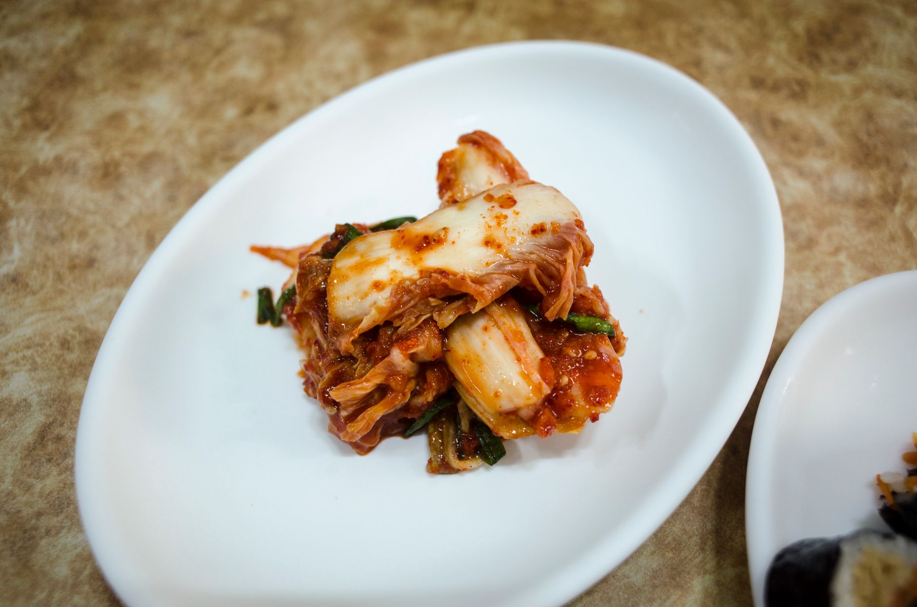 A plate of traditional fermented Korean kimchi presented elegantly on a white dish.