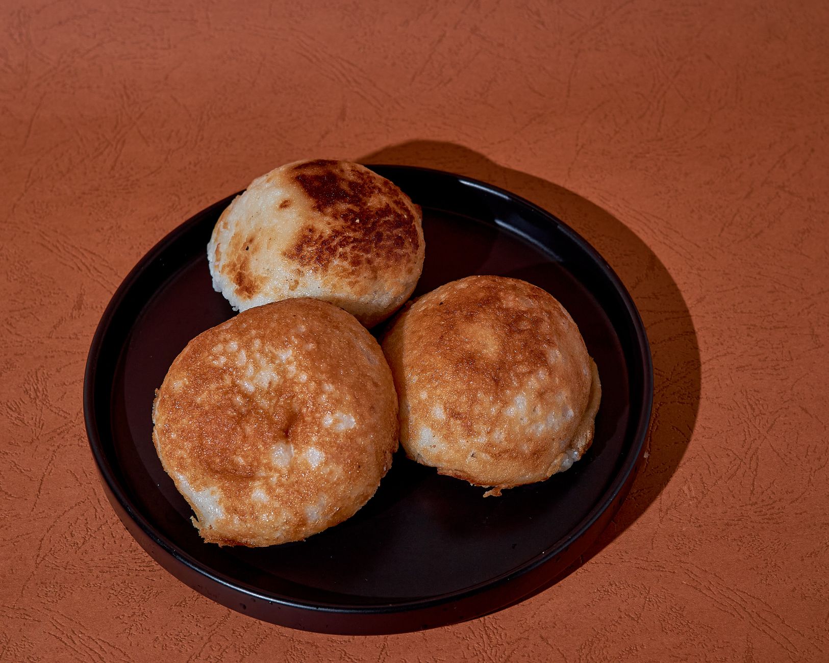 Top view of three freshly baked rice breads on a plate.