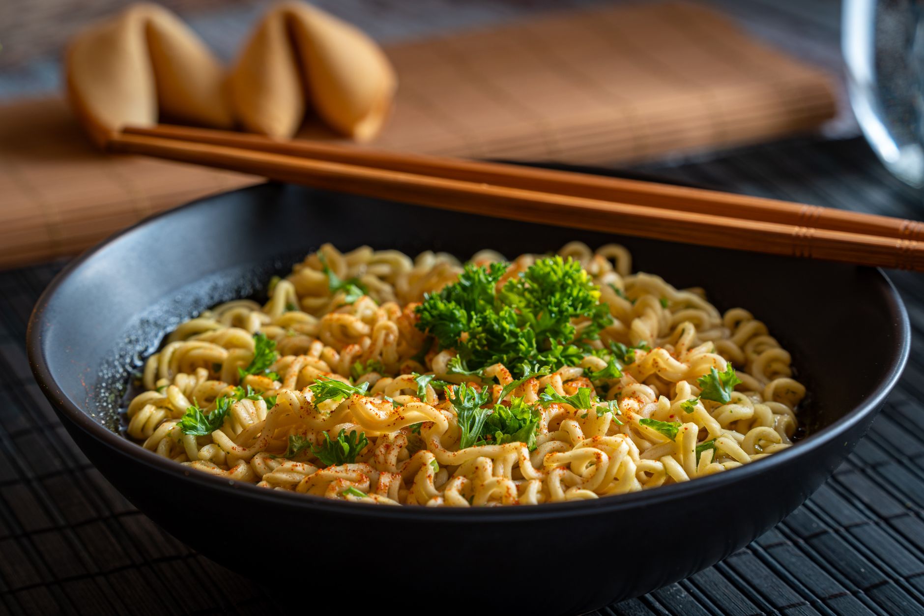 Savor a bowl of Asian-style noodles garnished with fresh parsley, served with fortune cookies.