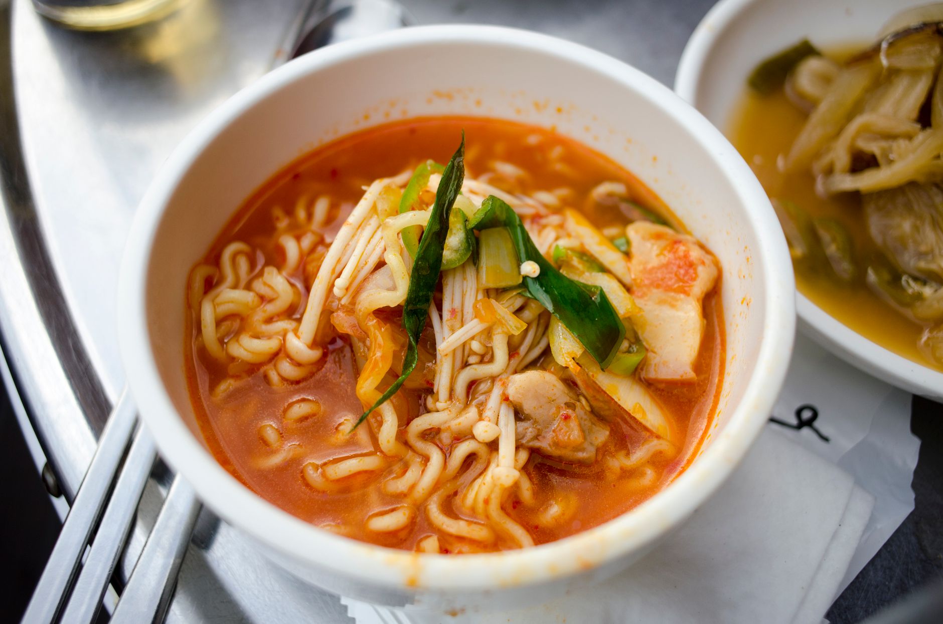 Close-up of delicious spicy ramen with vegetables in a bowl.