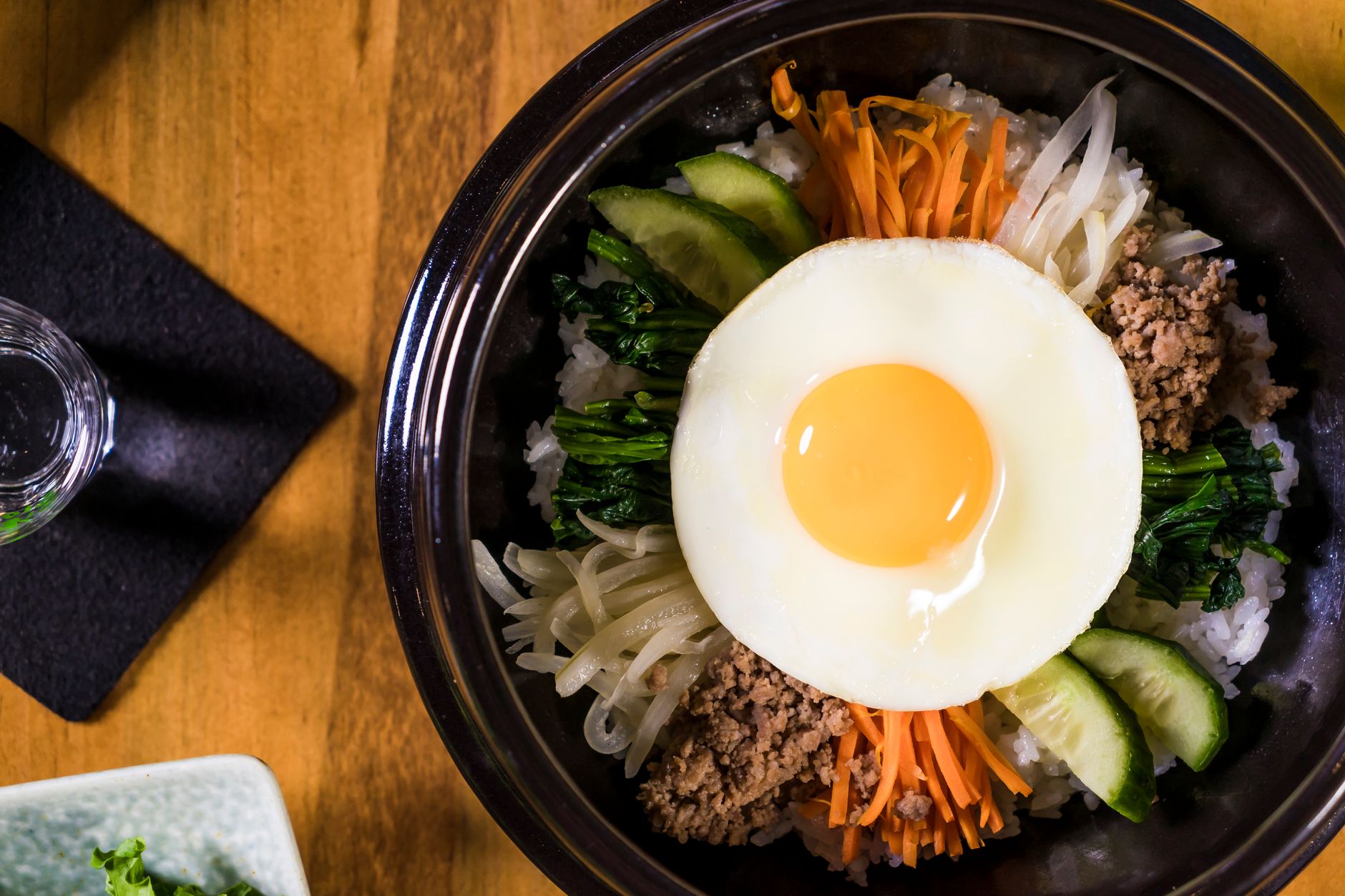 Delicious Korean Bibimbap dish featuring a fried egg, fresh vegetables, and savory beef, perfect for lunch or dinner.