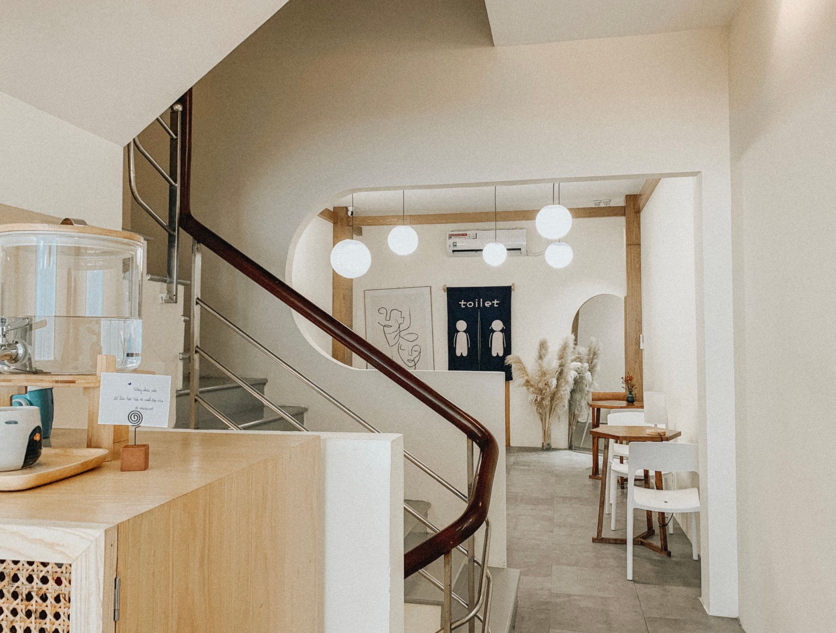 Stylish modern café interior featuring sleek stairs, elegant furniture, and ambient lighting.
