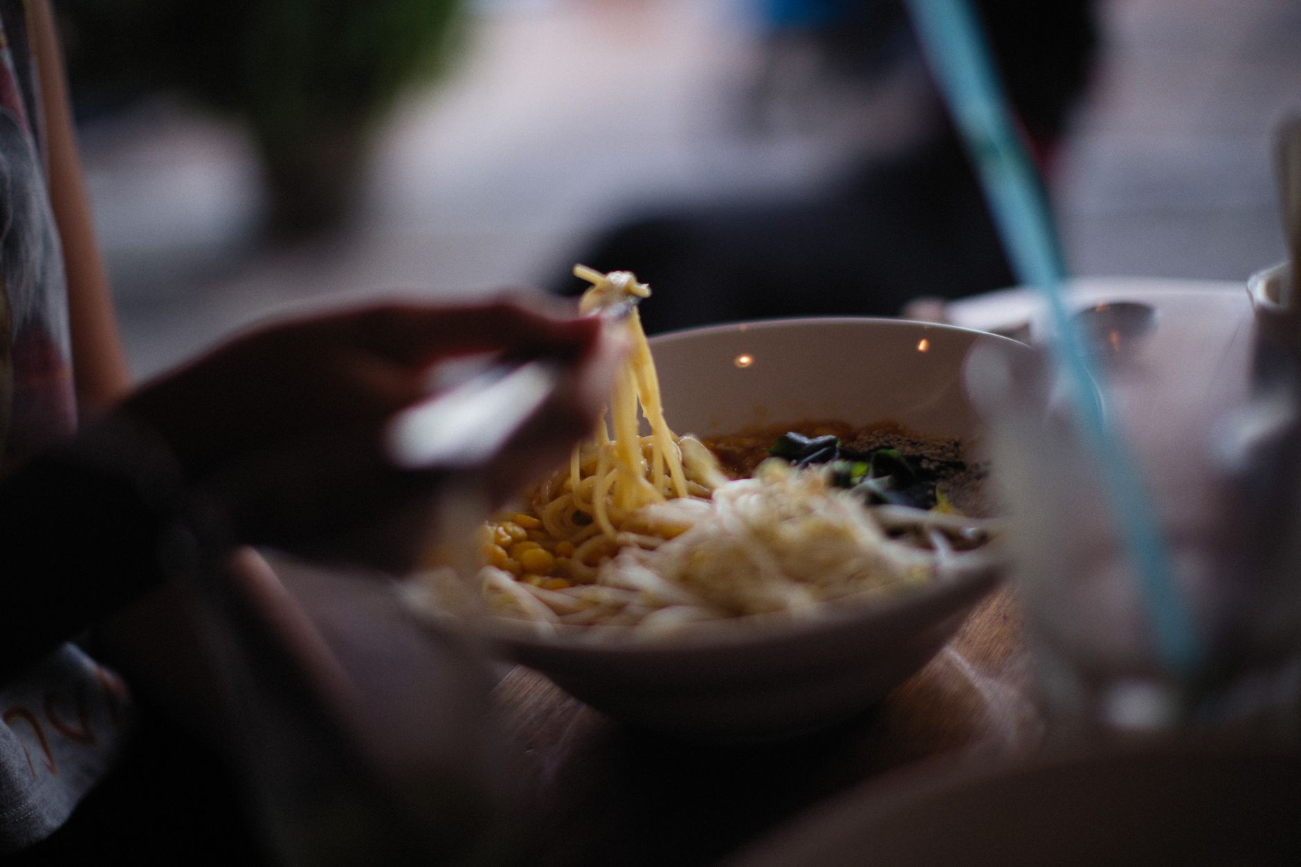 Close-up of a bowl of freshly served Asian noodle soup with chopsticks.