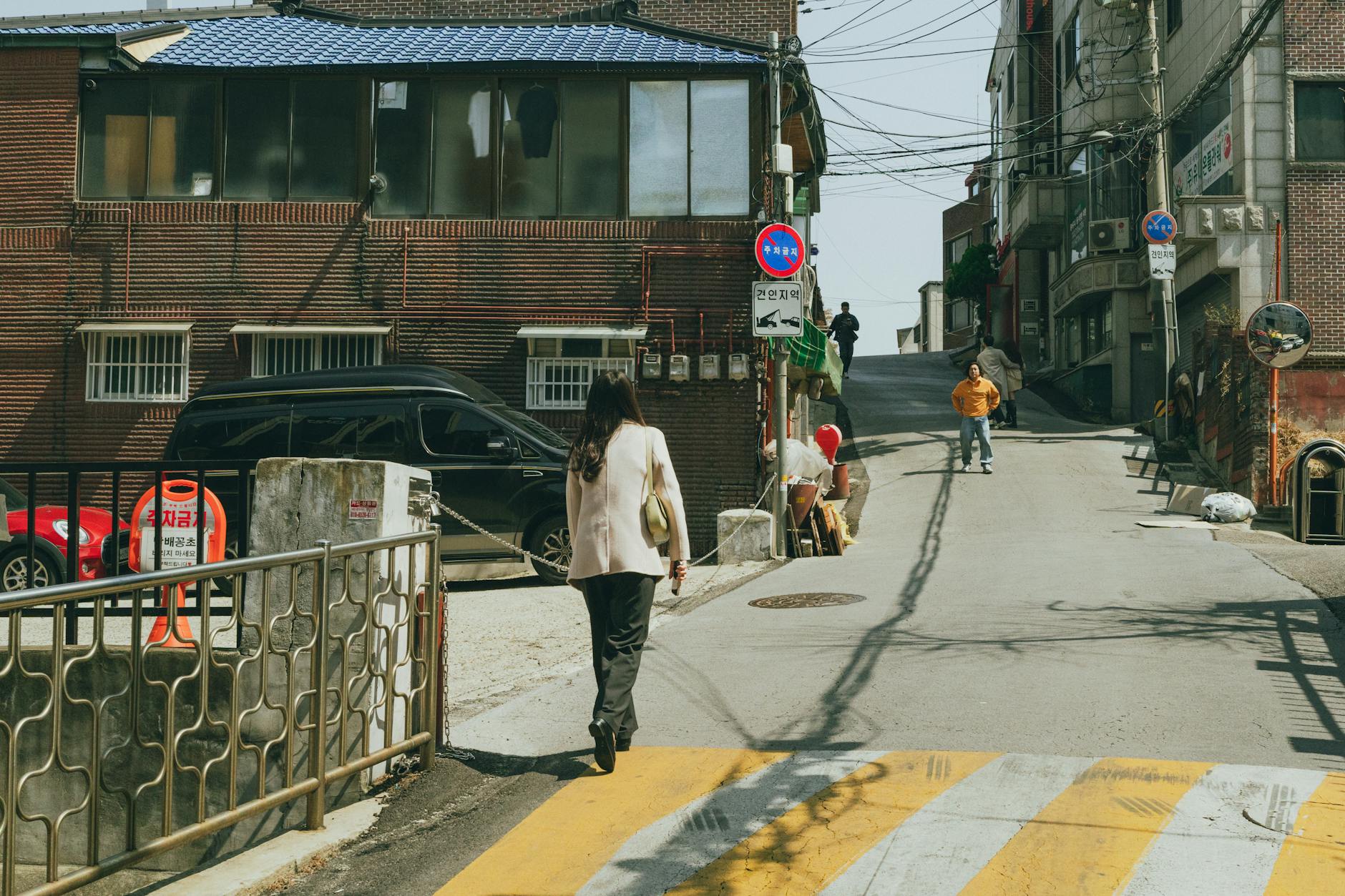 Explore daily life in a charming Seoul neighborhood with traditional architecture and bustling streets.