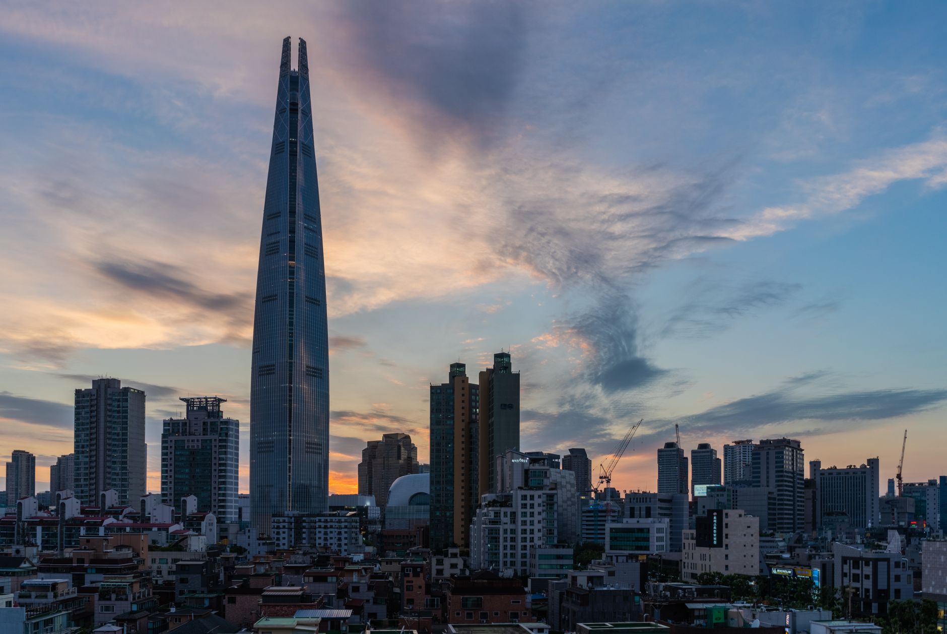 Dramatic skyline of Seoul with the prominent Lotte World Tower at twilight.